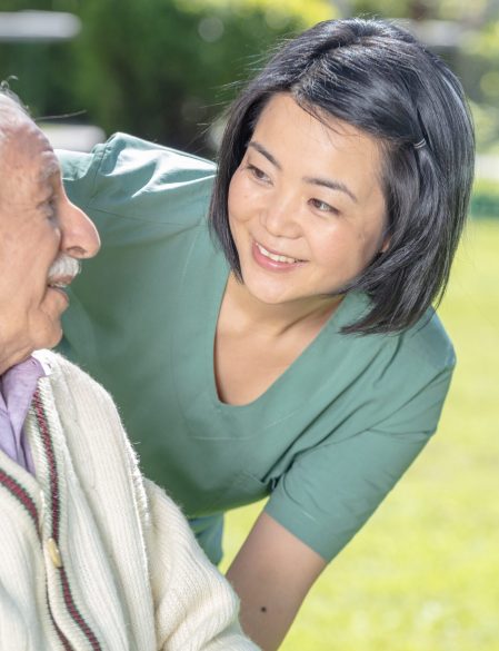 Asian female doctor playing and smiling with mature elderly man in the hospital garden.  Retirement community concept